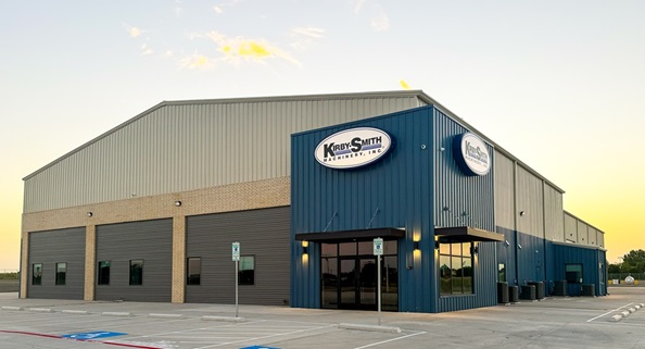 Exterior of Kirby-Smith Machinery's Van Alstyne facility showing service bays at dusk.
